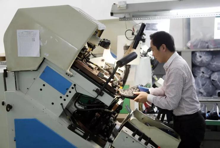 2015年1月7日,福建省莆田市一家规模鞋企的生产车间,工人操作机器对