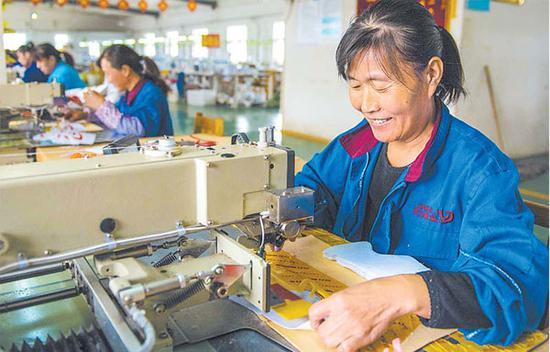 日前,贫困户在枣强县枣强镇河北京力鞋业生产车间工作.